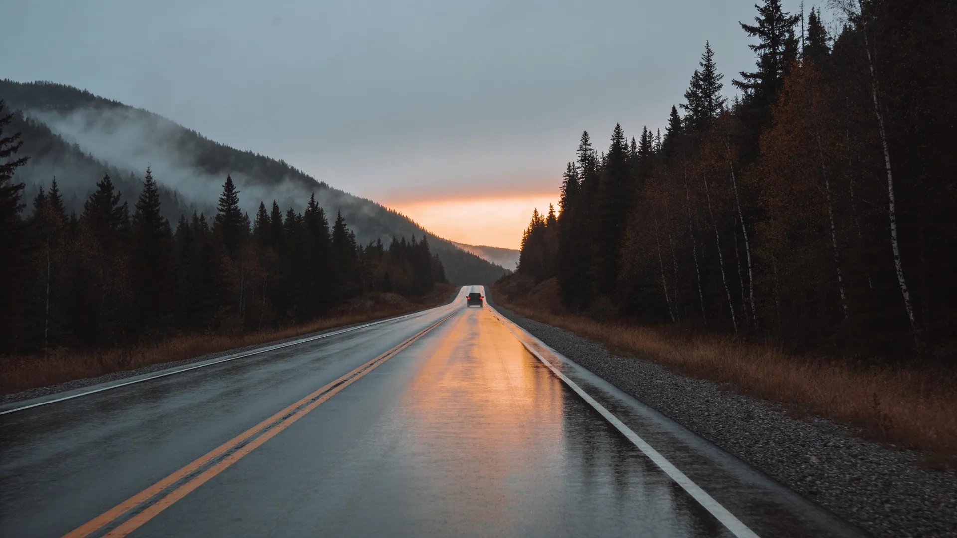 A vehicle on a mountain highway at dusk