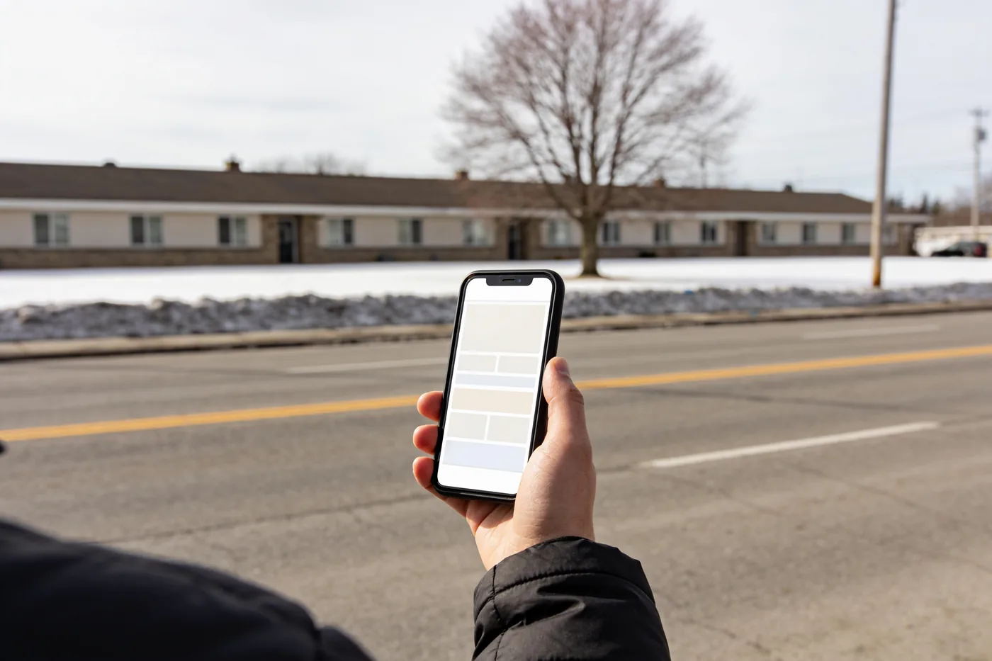 A person filling in a form on a phone, standing outside
