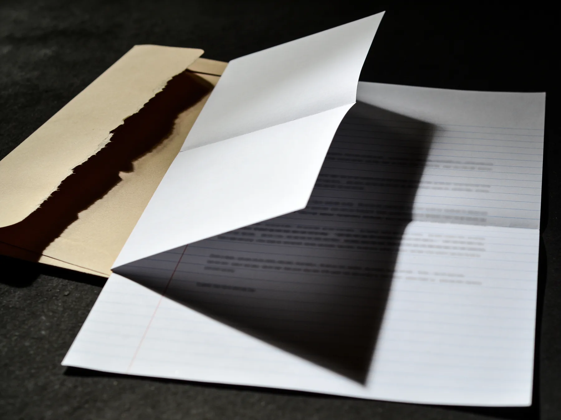 A printed credit report, folded, on a dark surface