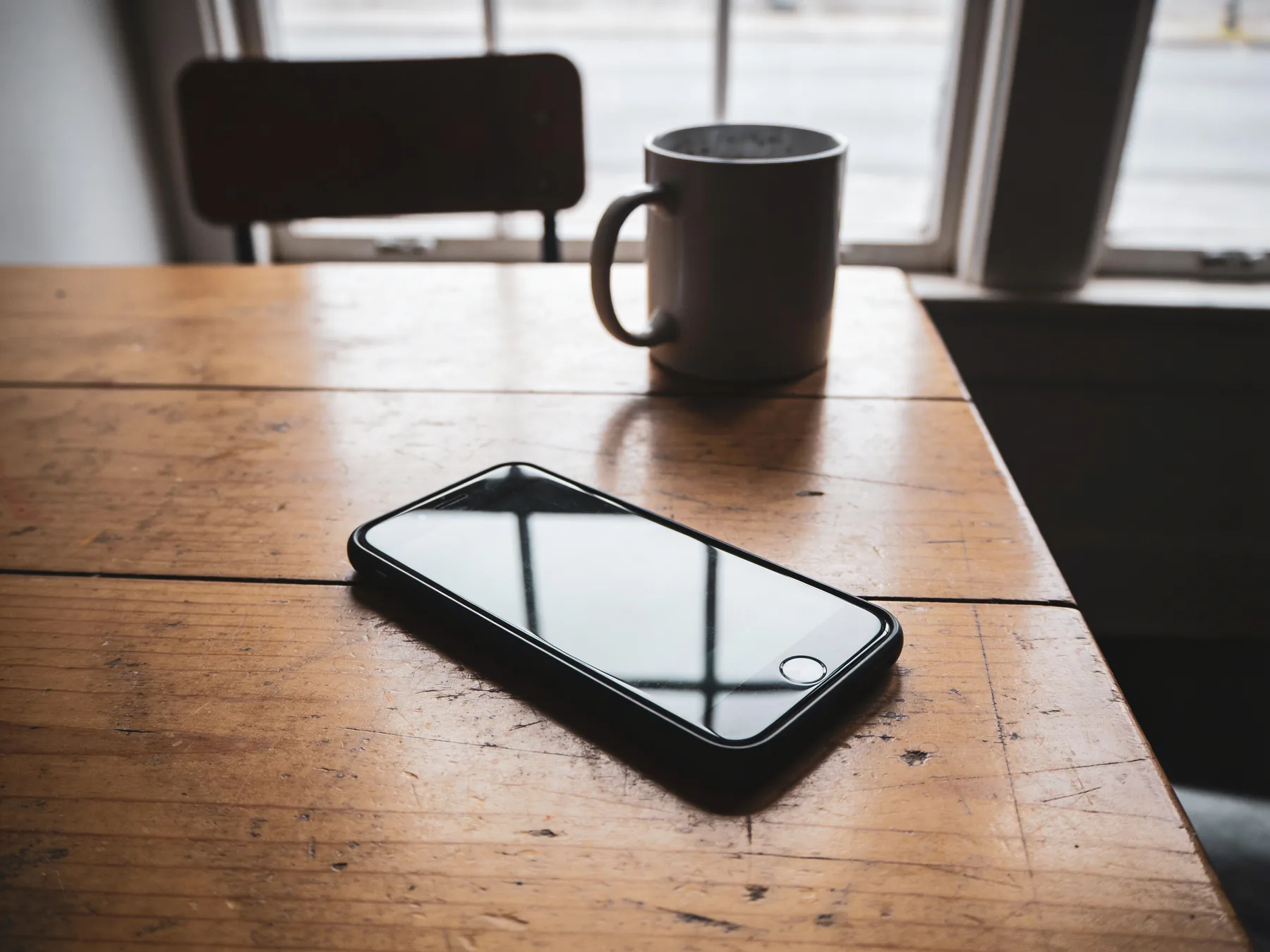 A phone face-up on a table with a form open on the screen